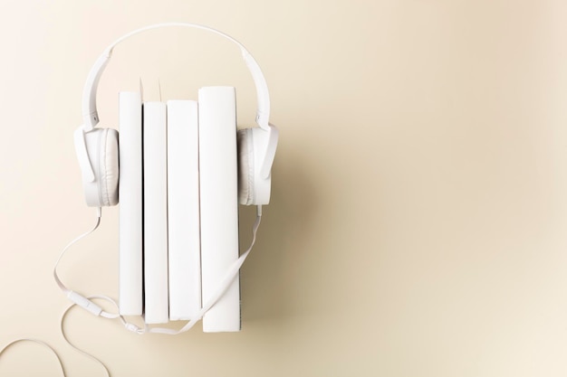 Vista superior de auriculares y cuadernos blancos sobre fondo con espacio de copia Lay Flat