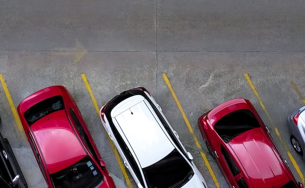 Vista superior del automóvil estacionado en el estacionamiento de concreto con línea amarilla de señal de tráfico en la calle.