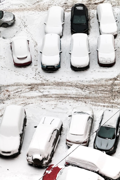 Vista superior de autos cubiertos de nieve en el estacionamiento