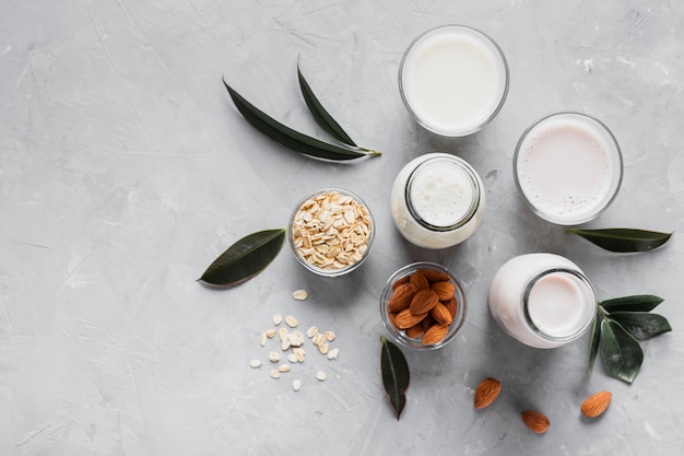 Foto vista superior de avena y almendras con vasos de leche y botellas