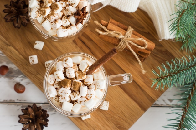 Vista superior de la bebida de chocolate con malvaviscos, ramas de canela, conos y ramas de abeto. el concepto de acogedoras vacaciones de Navidad y año nuevo.