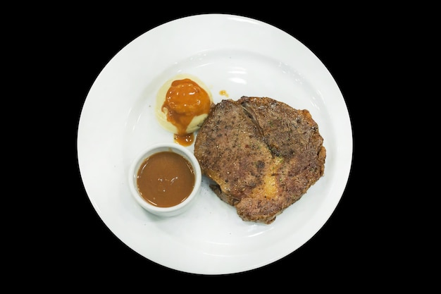 Vista superior de bistec con puré de papas de cerdo Kurobuta y enfoque selectivo de salsa marrón