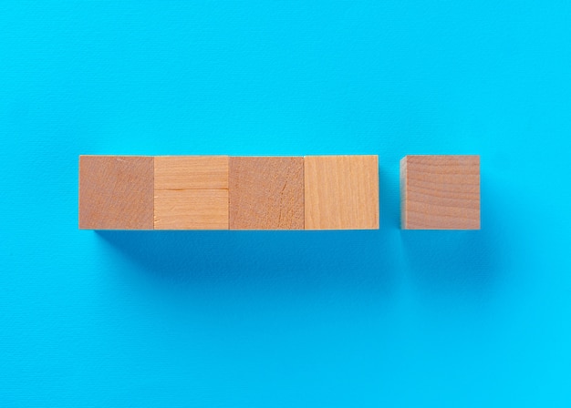 Vista superior de bloques de juguete de madera sobre fondo azul.