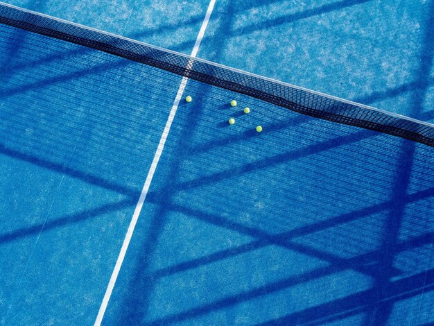 Vista superior de las bolas de tenis en un concepto deportivo de raqueta de cancha de tenis azul