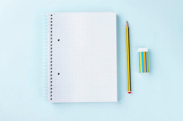 Vista superior del borrador de lápiz de bloc de notas en blanco sobre fondo azul claro Estudiar el concepto de negocio de la escuela