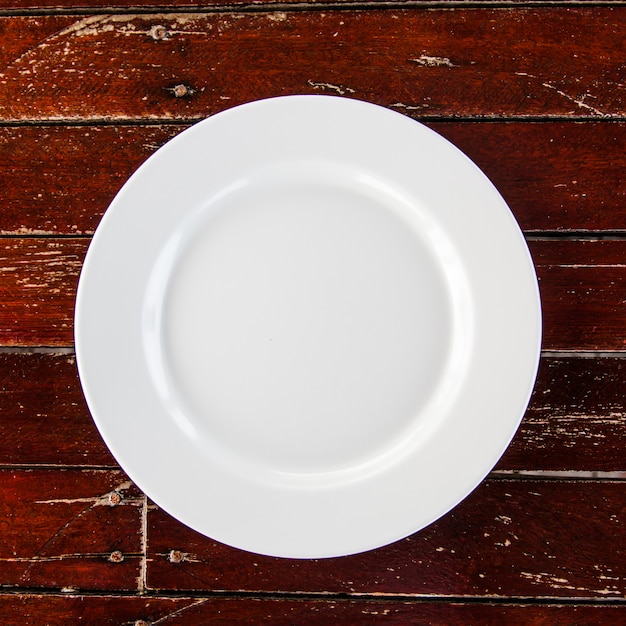 Vista superior branco prato na mesa de madeira