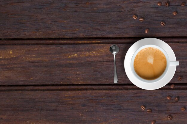 Vista superior del café con leche capuchino con frijoles aislados en la mesa de madera