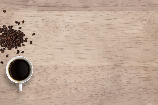 Vista superior café preto quente em xícaras e grãos isolados