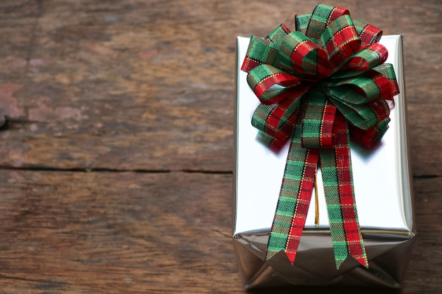 Vista superior de la caja de regalo y el arco de la vendimia presente puesto en el fondo de la mesa de madera