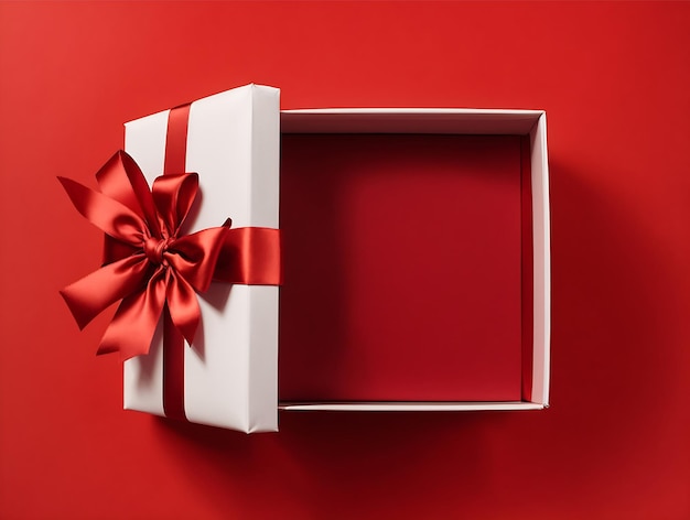 Vista superior de la caja de regalo blanca atada con un lazo de cinta roja aislado sobre fondo rojo oscuro