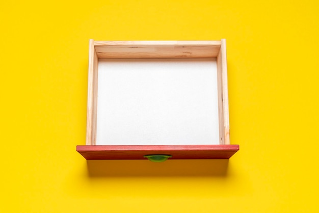 Foto vista superior del cajón vacío cajón de madera sobre un fondo amarillo