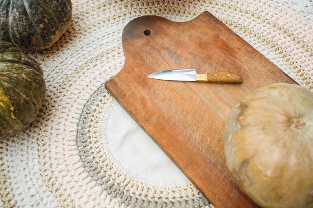 vista superior de calabaza y cuchillo sobre tabla de madera en el espacio de copia de la mesa