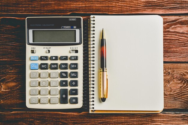 Vista superior de una calculadora con un bolígrafo y un cuaderno Concepto de educación en finanzas empresariales