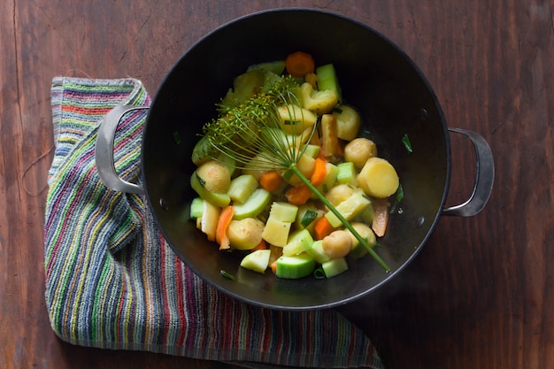 Foto vista superior de caldero con guiso caliente de verduras de temporada.