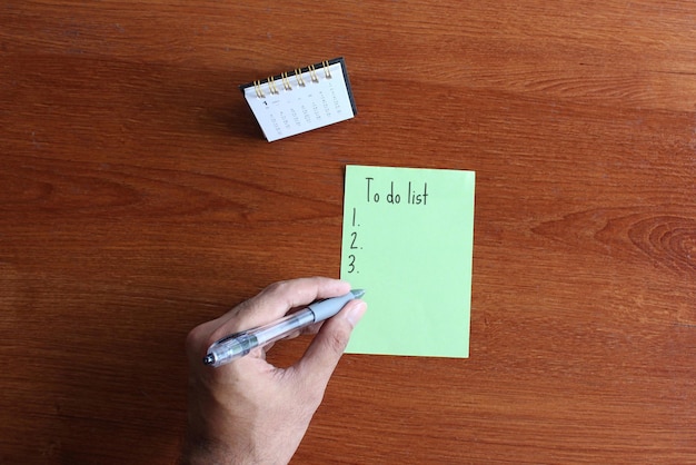 Vista superior del calendario de escritorio y papel con texto para hacer la lista