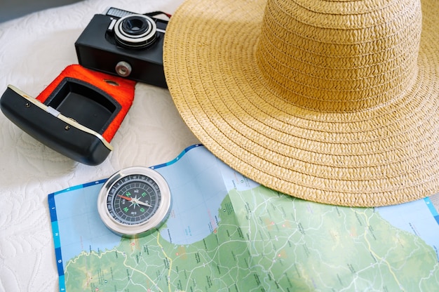 Vista superior de la cámara de la brújula del mapa y el sombrero de mujer para preparar el viaje