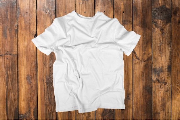 Vista superior de la camiseta blanca sobre fondo de madera