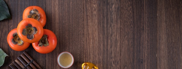 Vista superior de caquis frescos sobre fondo de mesa de madera para el año nuevo lunar chino