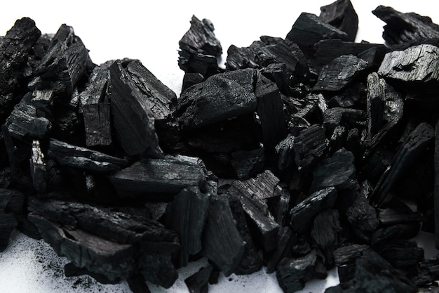 Vista superior de carbones negros sobre fondo blanco.