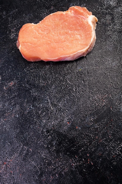 Vista superior de la carne cruda fresca sobre una mesa de madera negra. Comida gourmet y comida fresca sin cocinar