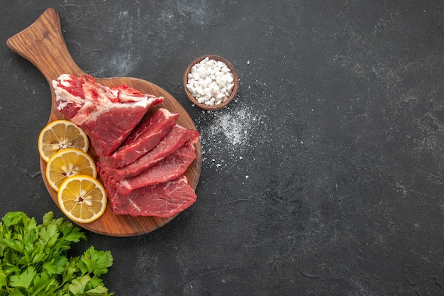 Vista superior de carne fresca en rodajas con rodajas de limón y verduras