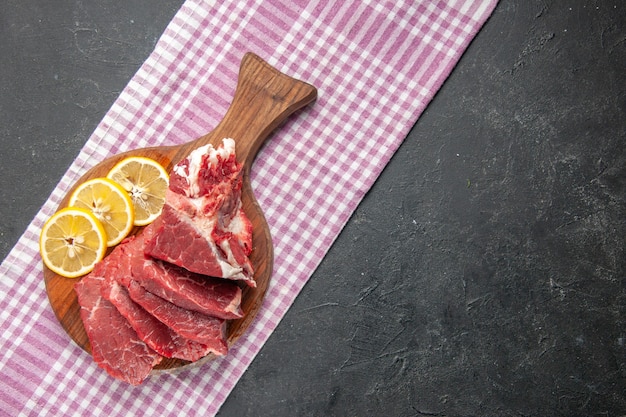 Vista superior de carne fresca en rodajas con rodajas de limón