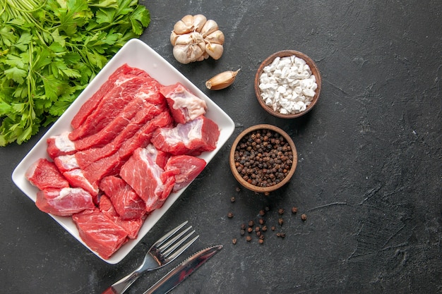 Vista superior de carne fresca en rodajas con verduras y condimentos