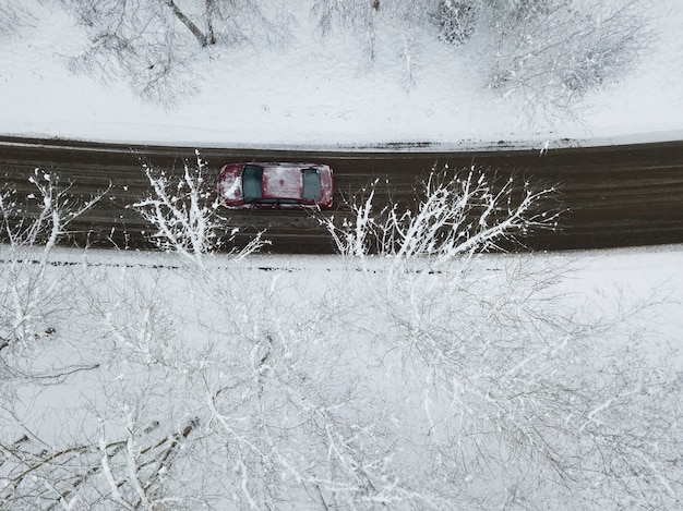 Vista superior de la carretera a través del bosque nevado en el que se conduce el coche