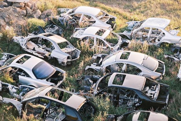 Vista superior del cementerio de coches rotos viejos coches oxidados tirado en la hierba