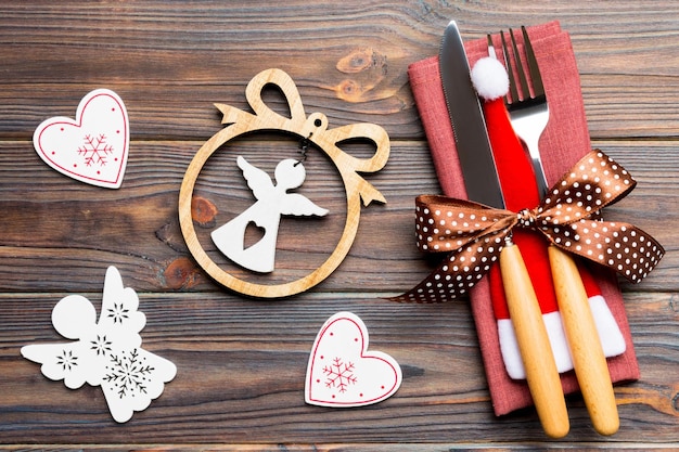 Vista superior de la cena de Año Nuevo en fondo de madera Cubiertos festivos en servilleta con decoraciones y juguetes navideños Primer plano del concepto de vacaciones familiares