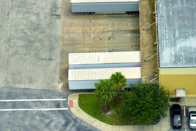 Vista superior del centro logístico gigante con muchos camiones de remolque comerciales que descargan y cargan productos minoristas para su posterior envío Concepto de economía global