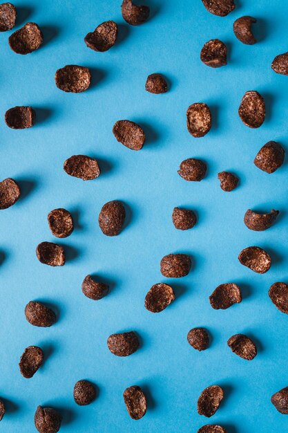 Vista superior de cereales aislados de copos de maíz con chocolate sobre fondo azul Concepto de desayuno