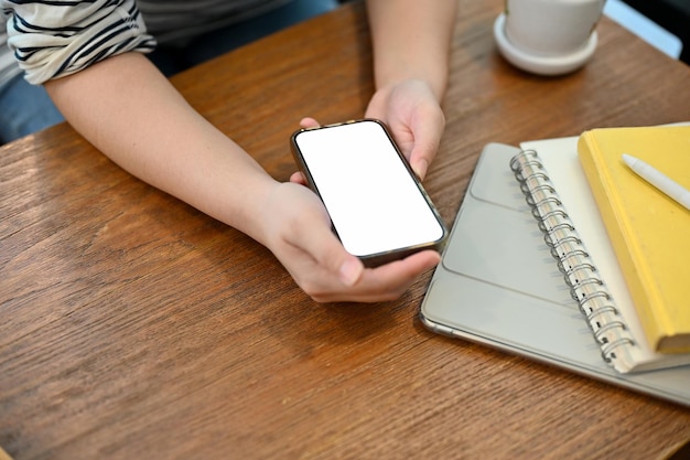 Vista superior de una chica asiática usando su teléfono inteligente en un café