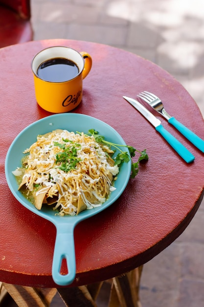 Vista superior de chilaquiles mexicanos y café para el desayuno