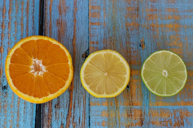 Vista superior de cítricos cortados por la mitad colocados en una mesa de madera envejecida azul