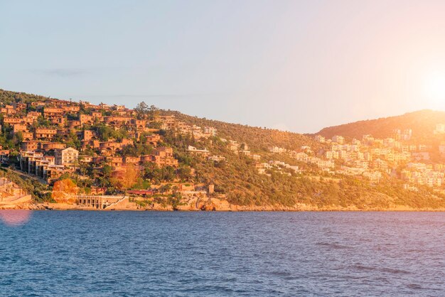 Vista superior de la ciudad turística en las montañas cerca del mar azul a la luz del sol