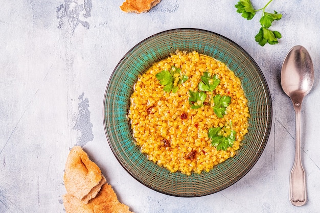 Vista superior de la cocina vegana de sopa de lentejas en un tazón