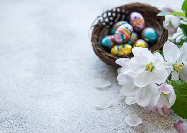 Vista superior de coloridos huevos de pascua y flores de primavera sobre fondo de hormigón