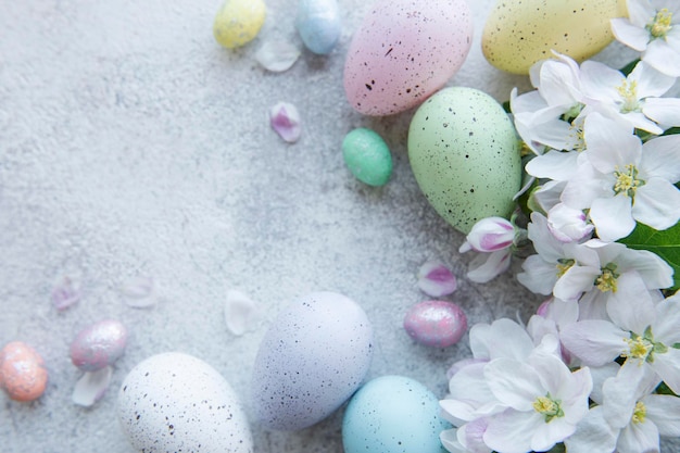 Vista superior de coloridos huevos de pascua y flores de primavera sobre fondo de hormigón