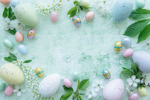 Vista superior de coloridos huevos de Pascua sobre fondo de madera verde
