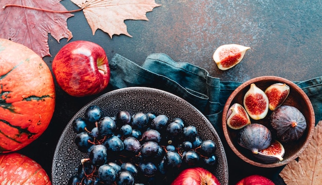 Vista superior de comida de otoño manzanas rojas higos uvas y calabaza