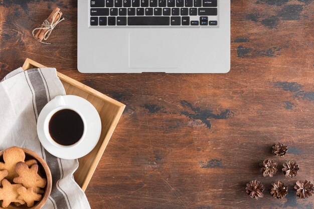 Vista superior de la computadora portátil, hombre de jengibre, taza de café en madera rústica oscura