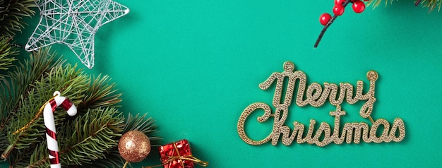 Vista superior del concepto de diseño de fondo de Navidad con rama de abeto y adornos sobre fondo de mesa verde.