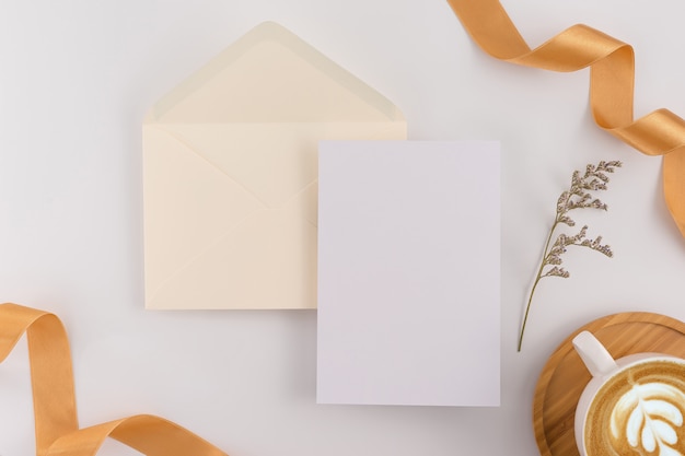 Foto vista superior, configuração lisa, cartão do convite do casamento, envelopes, papéis de cartões no fundo branco.