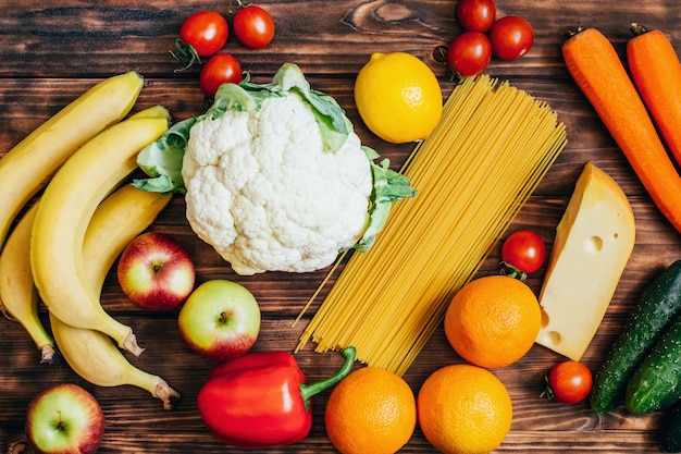 Vista superior conjunto de alimentos verduras frutas productos lácteos en madera