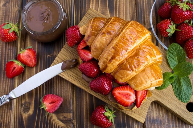 Vista superior de croissant con crema de chocolate y fresas