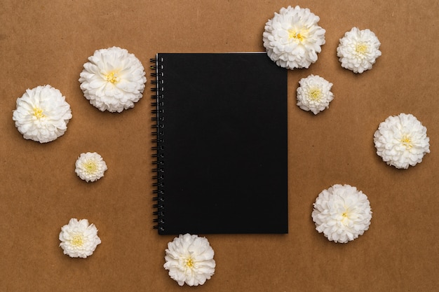 Foto vista superior cuaderno y flores