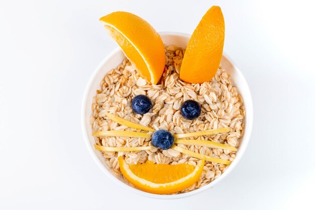 Foto vista superior un cuenco de avena decorado con frutas frescas en forma de cara de conejo