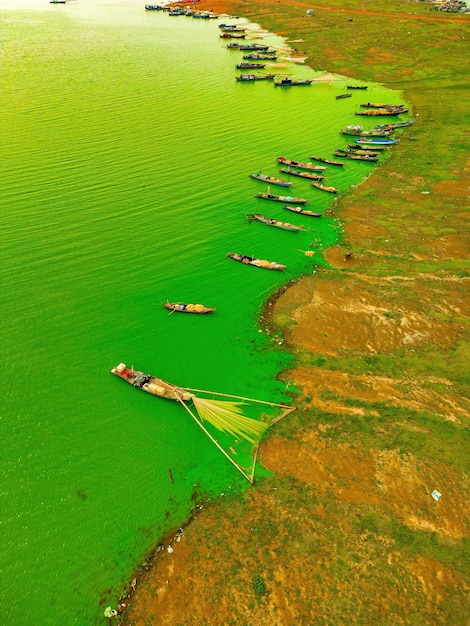 Vista superior da aldeia de pescadores de Ben Nom imagem verde fresca da temporada de algas verdes no lago Tri An com muitos barcos de pesca tradicionais ancorados em Dong Nai, Vietnã