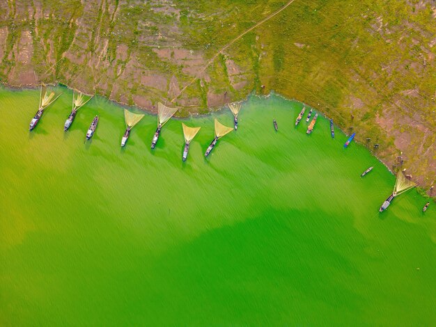 Vista superior da aldeia de pescadores de Ben Nom imagem verde fresca da temporada de algas verdes no lago Tri An com muitos barcos de pesca tradicionais ancorados em Dong Nai, Vietnã